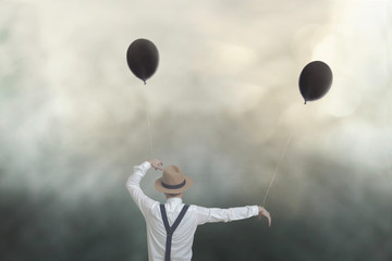 surreal image of a marionette man controlled by two wires with balloons