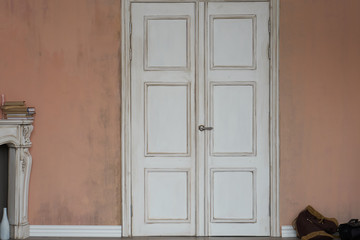 The white door is closed in the Studio and standing next to the fireplace. A dark handle is...