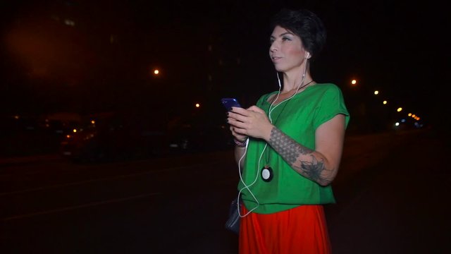 girl hooker on the road uses a smartphone