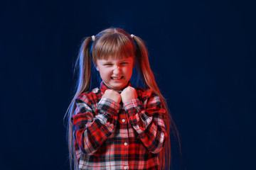 Portrait of angry little girl on dark background