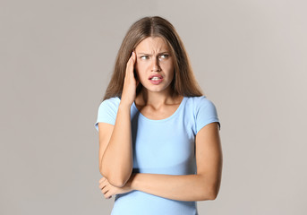 Obraz premium Stressed young woman on grey background