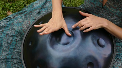 Beautiful female hands on a perfect musical percussion instrument.