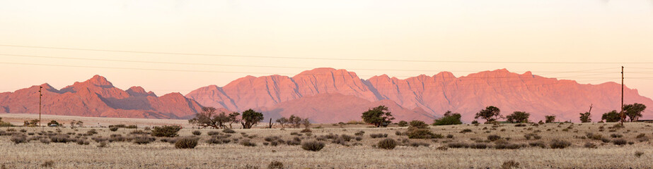 Naklejka premium Red lighted mountain range in the desert of Namibia, Namib Naukluft Park