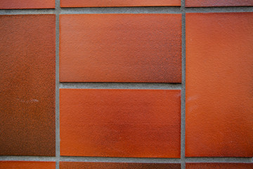 Fototapeta premium Old red brick wall. Old concrete wall. The facade of the house built of solid stone cement