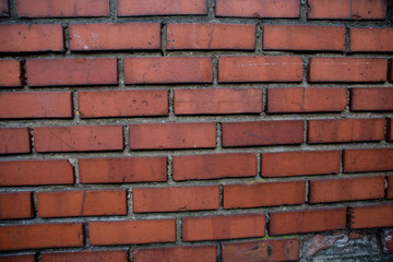 Old red brick wall. Old concrete wall. The facade of the house built of solid stone cement