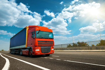 Red truck is on highway - business, commercial, cargo transportation concept