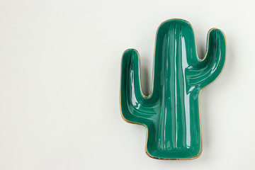 Green Cactus Shaped Plate on white background for serving salads and snacks, copy space, horizontal orientation