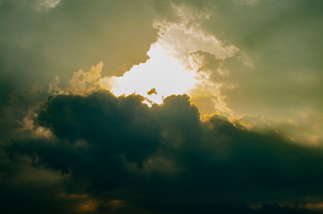 Fototapeta premium The Sunset Sky is Covered with Clouds. The Dark Thick Clouds and the Light Break Through them.
