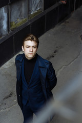 portrait of an attractive young man in a blue suit in the city