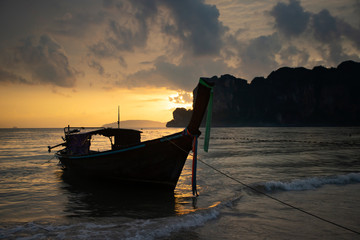 Amazing sunset with longtail boats silhouette at Railay beach, Thailand.