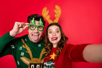 Photo of childish lady and guy at x-mas costume party making selfies wear ugly knitted pullovers...