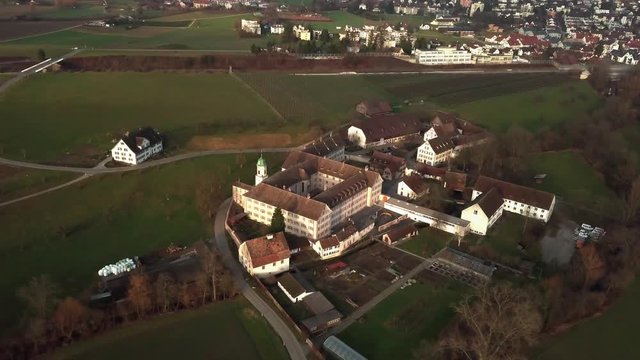 Wide aerial drone shot orbiting around Fahr Monastery in Unterengstringen, Switzerland 60fps