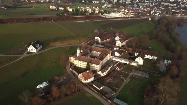 Wide aerial drone shot orbiting around Fahr Monastery in Unterengstringen, Switzerland