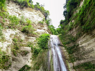 Fototapeta na wymiar Tropical waterfall in green forest beautiful Dao Falls in jungle, Philippines, Cebu. Waterfall in the tropical forest.