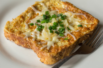 Savoury French toast topped with chopped green spring onions and melted cheese