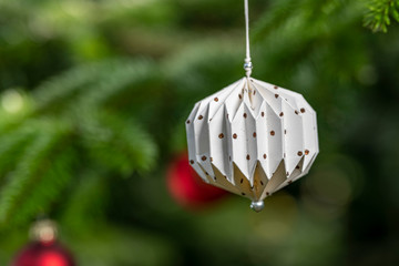 Weihnachtsschmuck an einem Tannenbaum aus papier , Lebkuchen oder Glas