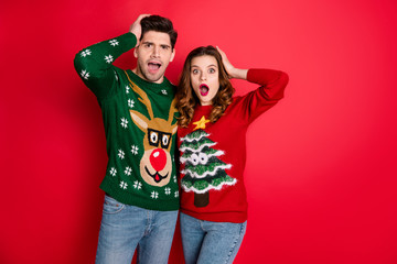 Portrait of impressed hipster couple hear unbelievable news scream wow omg wear deer christmas tree...