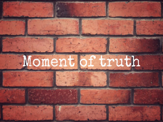 Motivational and inspirational wording - Moment Of Truth written on a brick wall. Blurred styled background.