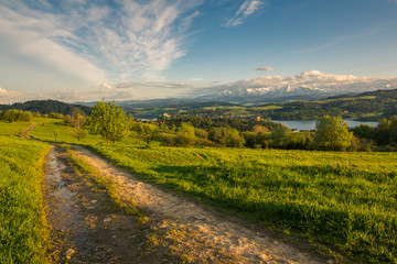 Panorama of snowy Tatra mountains and castle in Czorsztyn during spring sunset, Malopolskie, Poland