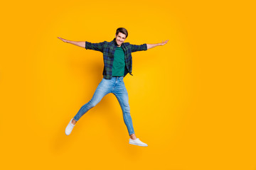 Full length photo of cheerful funny positive man jump hold hand like wings enjoy weekends summer spring holidays wear god-looking outfit isolated over yellow color background