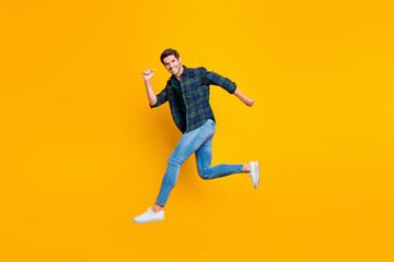 Fototapeta na wymiar Full length body size photo of cheerful attractive handsome guy going jumping somewhere trendy wearing jeans denim isolated over vivid color background