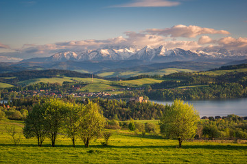 Panorama of snowy Tatra mountains and castle in Czorsztyn during spring sunset, Malopolskie, Poland