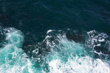 Top view on ocean waves and foam.