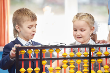 teacher teaches children mental arithmetic using large abacus soroban
