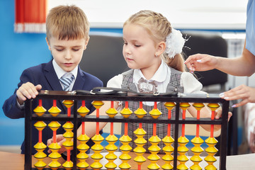 teacher teaches children mental arithmetic using large abacus soroban
