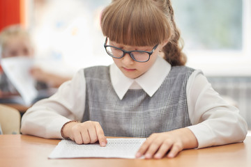 Naklejka na ściany i meble schoolgirl with a scythe and glasses solves problems in mathematics