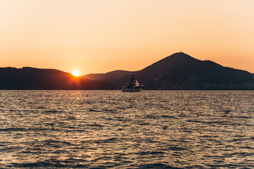 Beautiful view of the sunset and the natural landscape with the sea and hills or mountains in Montenegro in the summer.
