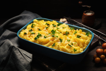 Baked macaroni and cheese dish against dark wooden background.