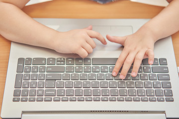 Fototapeta na wymiar close-up of schoolgirl hands typing on laptop