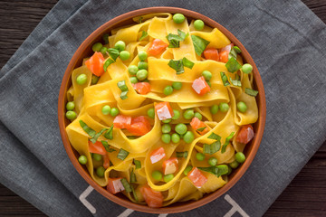Fettuccine with salmon, peas and herbs. Healthy food with omega acid. The main ingredients are...