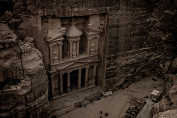 old style photography of Petra treasure world famous touristic heritage site on Jordan Middle East country ancient building exterior facade foreshortening from above in evening twilight time 