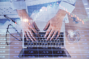 Double exposure of market chart with man working on computer on background. Concept of financial analysis.