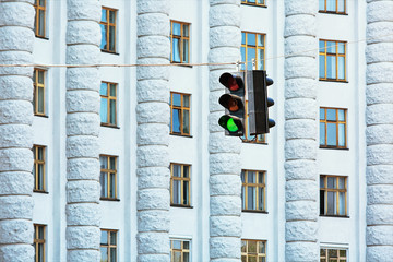 Green traffic lights against big administrative building