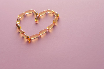 Close up capsules of fish fat oil in the heart shape, omega 3,