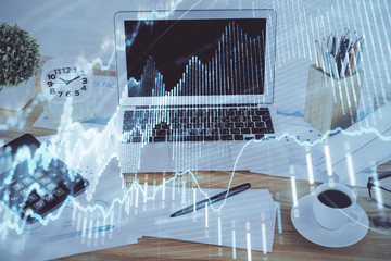 Stock market graph on background with desk and personal computer. Double exposure. Concept of financial analysis.