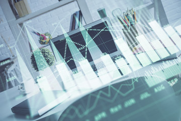 Fototapeta premium Stock market graph on background with desk and personal computer. Double exposure. Concept of financial analysis.