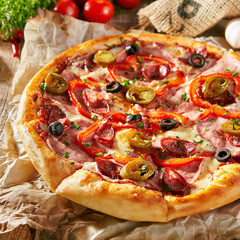Pizza Restaurant Menu - Delicious Spicy Pizza with Sausages and Chili Pepper. Pizza on Rustic Wooden Table with Ingredients