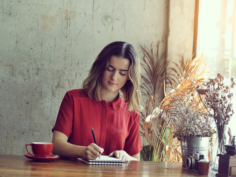 Beautiful woman writing for idea with her work in coffee shop, lifestyle
