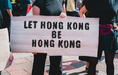 Protest in Hong Kong. Protestor holds a cardboard with an inscription: Let Hong Kong Be Hong Kong....