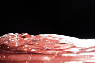 bright beautiful juicy red water with iridescent showy waves on a black background