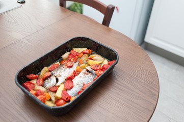 Fresh Baked fish with vegetables and potatoes in pan