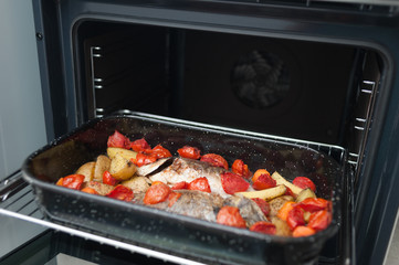 Fresh Baked fish with vegetables and potatoes in pan