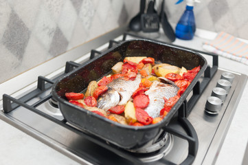 Fresh Baked fish with vegetables and potatoes in pan