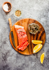 Salmon raw, red fish steak with herbs and lemon. Top view.