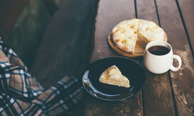 Fresh homemade peach pie and black tea on a cozy terrase.