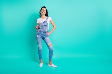 Full length body size view of her she nice attractive lovely pretty cheerful cheery content girl wearing blue overall posing isolated over bright vivid shine vibrant green turquoise background